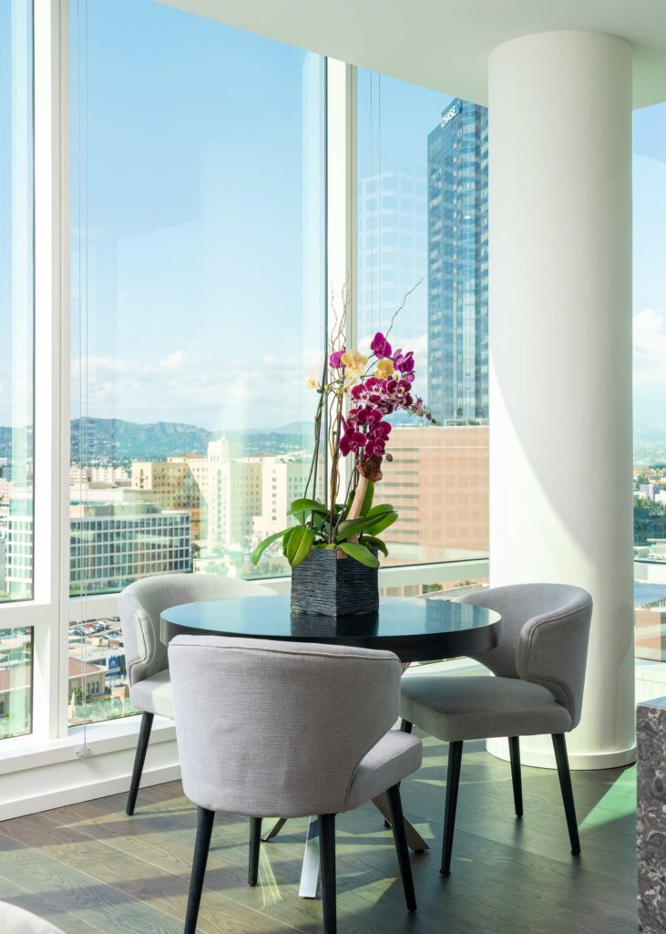 Residences in Downtown, LA - THEA at Metropolis - Circle Table, Decorative Flowers, Wood Flooring, and Spacious Windows