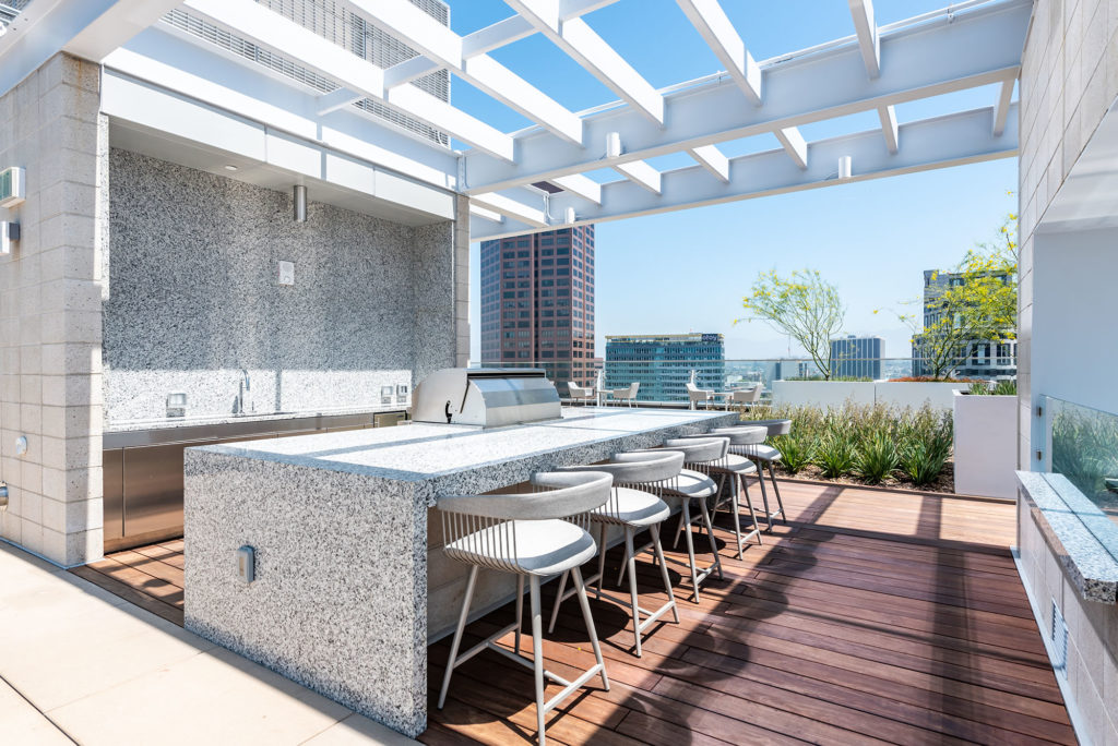 Residences in Downtown Los Angeles - THEA at Metropolis - Outdoor Grill Area with Grey Marble Infinity Countertop, Stainless Steel Grill, and Seating