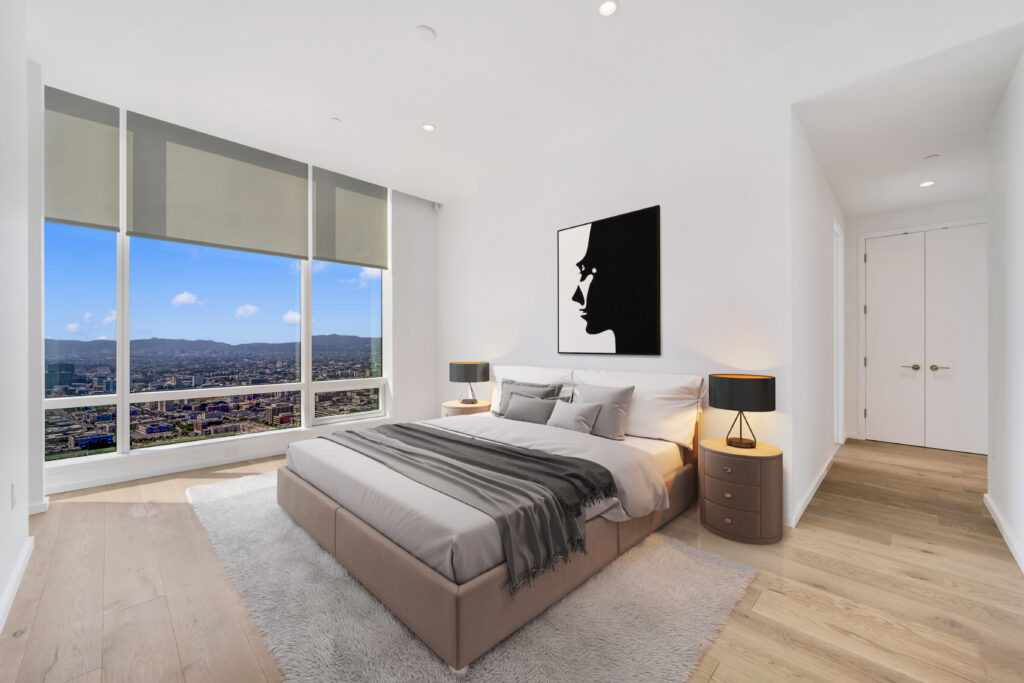 Bedroom with gray bed and large windows with hilly views
