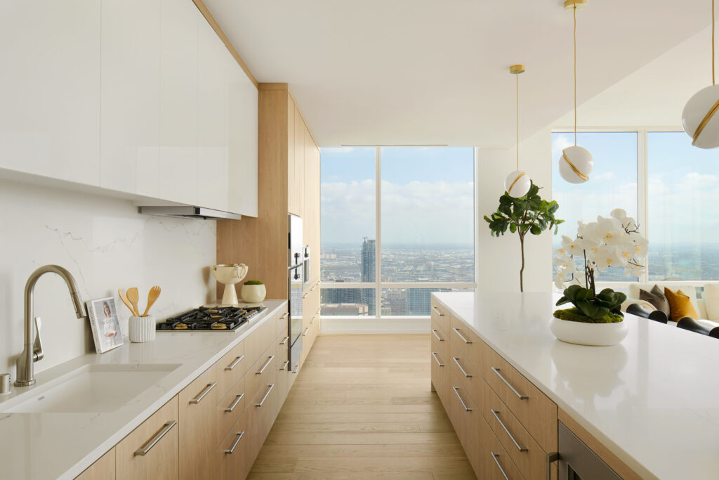 Kitchen with white countertops and wooden cabinetry with floor-to-ceiling windows